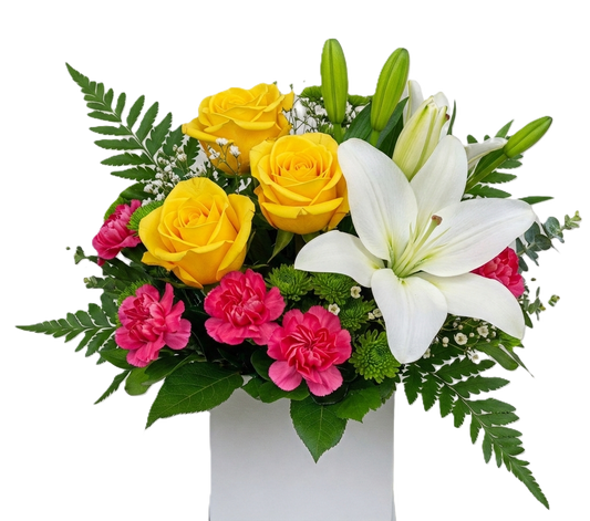 Bouquet of yellow roses, pink carnations, and white lilies in a white box ready to go arrangement. 
