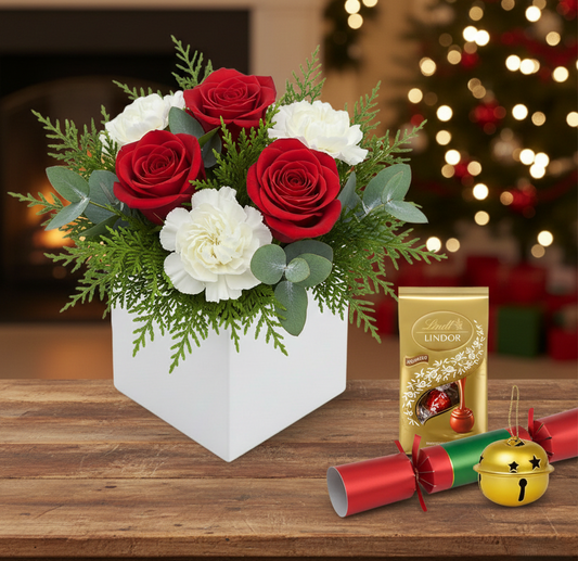 Festive Crimson & Snow gift set featuring red and white flowers, a jingle bell, and chocolates, hand-crafted for holiday delivery in South Auckland.