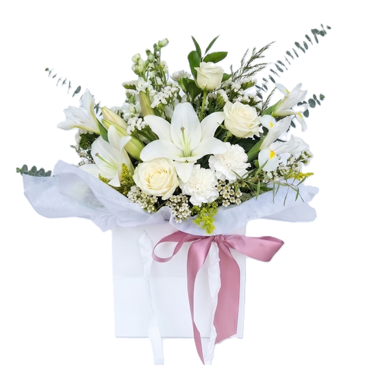 A beautiful bouquet of top quality white roses and fresh premium greenery wrapped in paper